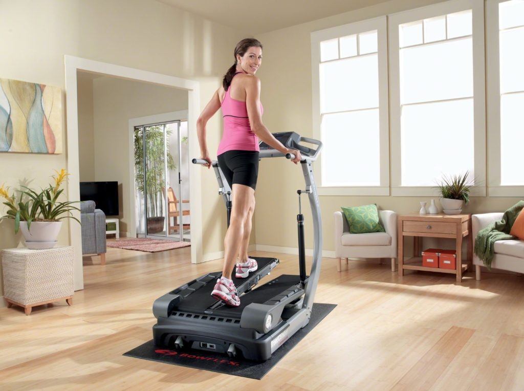 Woman using a bowflex treadclimber near a window